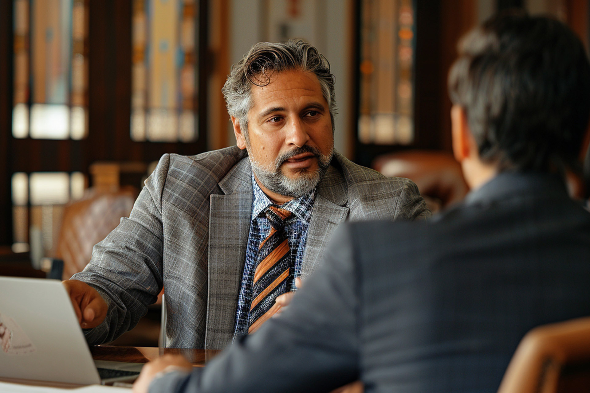 a male retaliation lawyer in Huntingdon beach discussing a case with a client at a desk