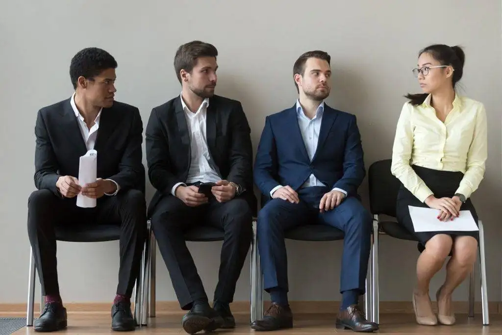 three men in suits sat next to a woman