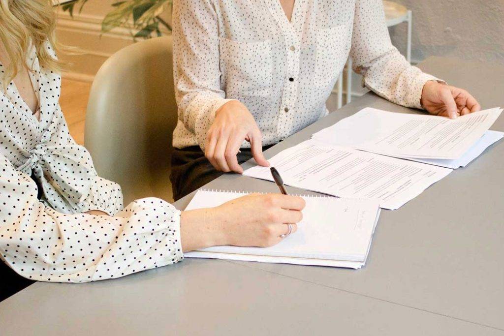 two people sat at a desk with employment law paperwork