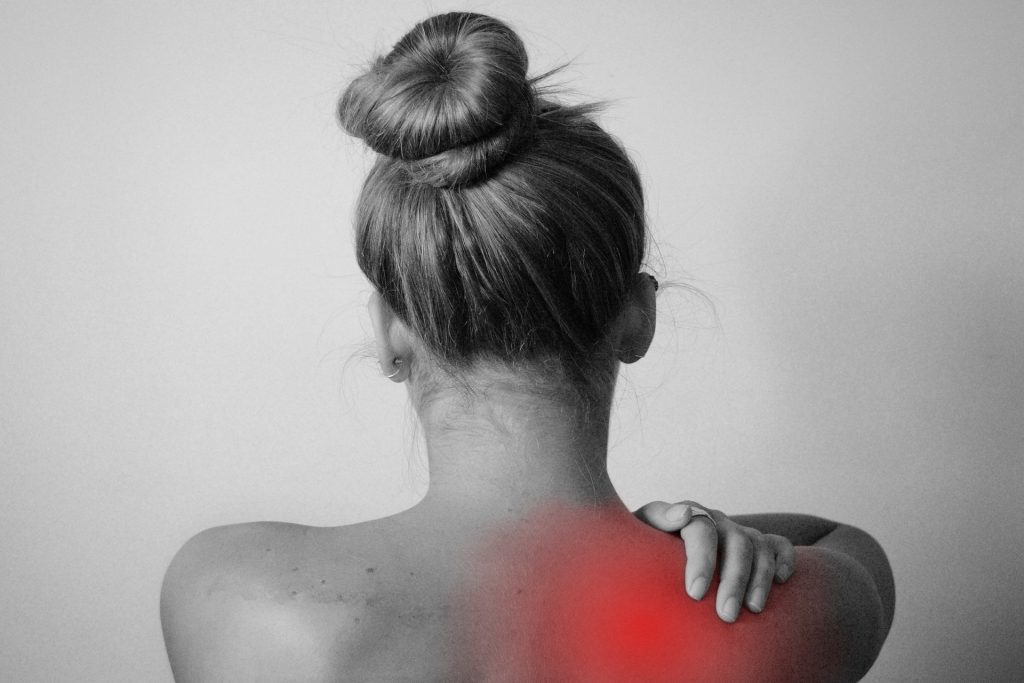 A grayscale image emphasizing shoulder pain with a red glow