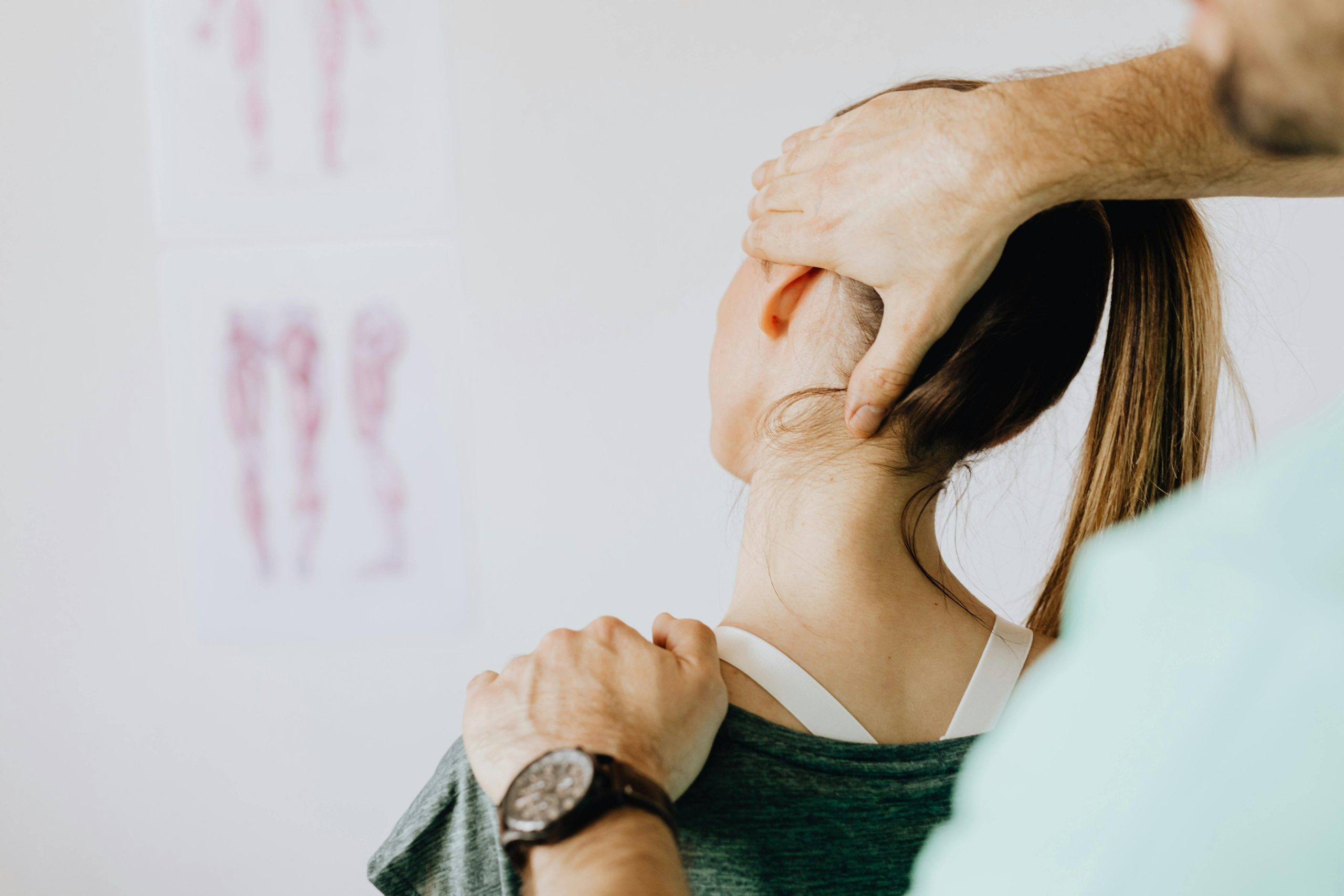 A practitioner positions a patient’s head for spinal therapy