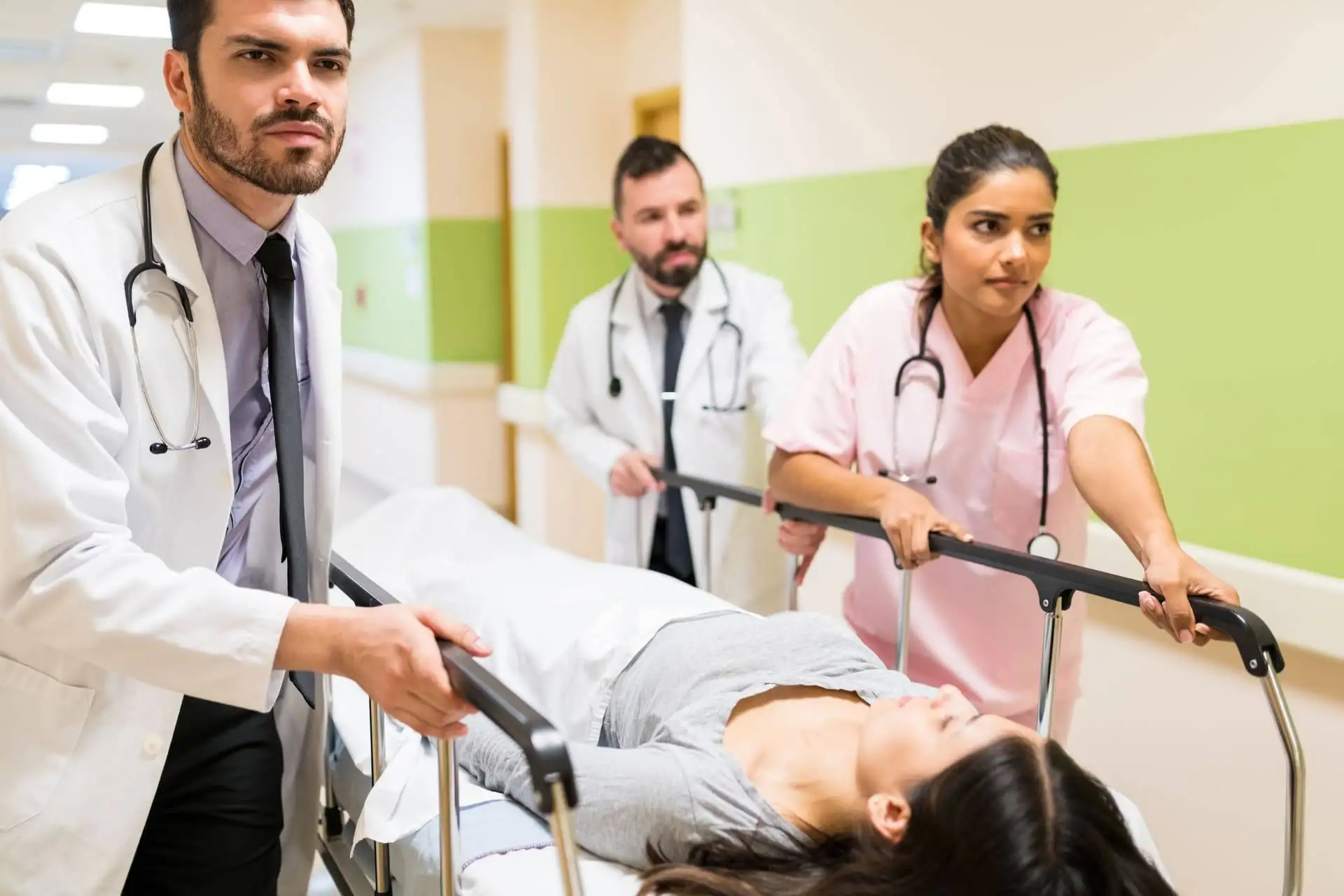Doctors and nurses pushing a patient on a hospital gurney in a corridor
