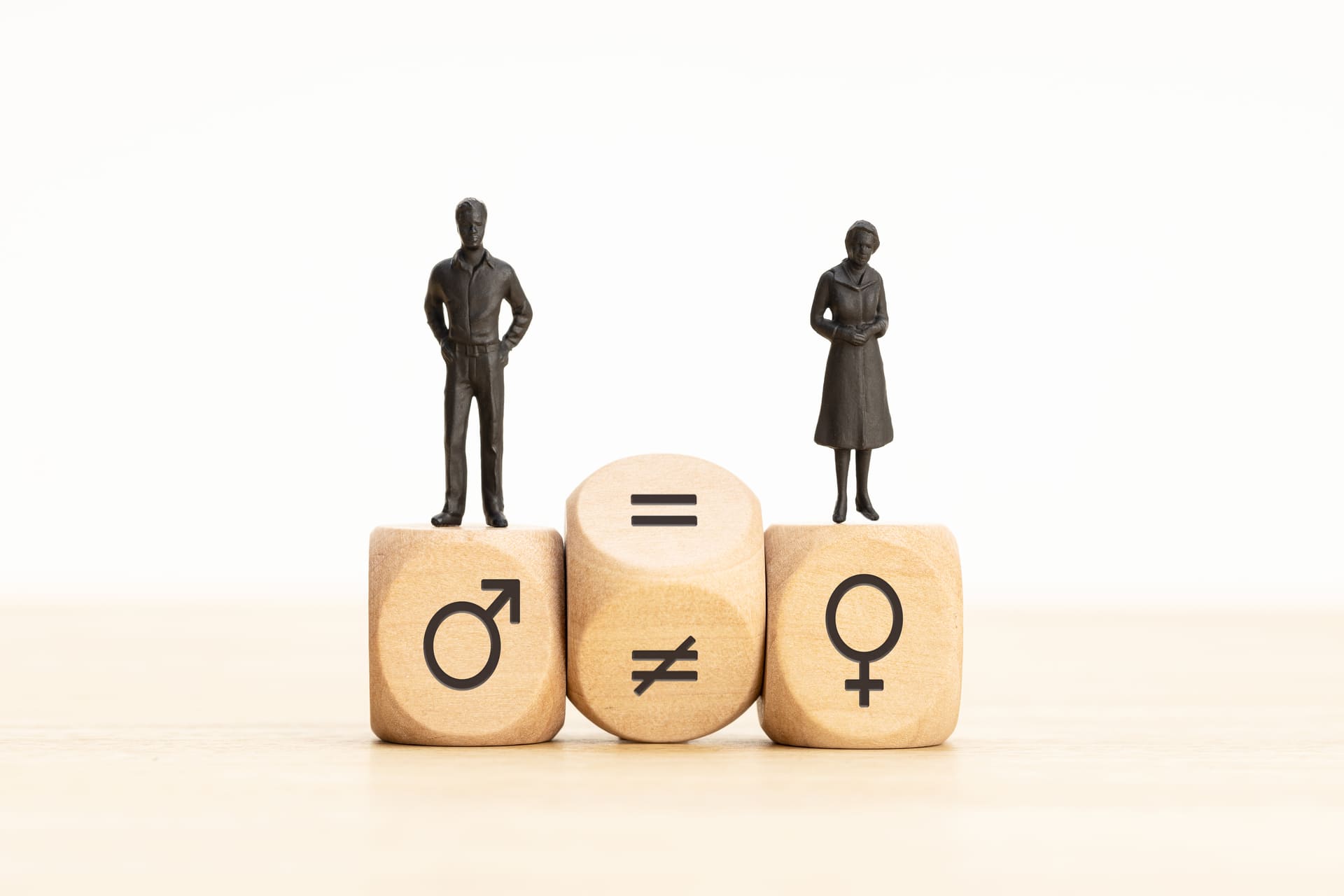 Gender equality concept with male and female figures on dice blocks