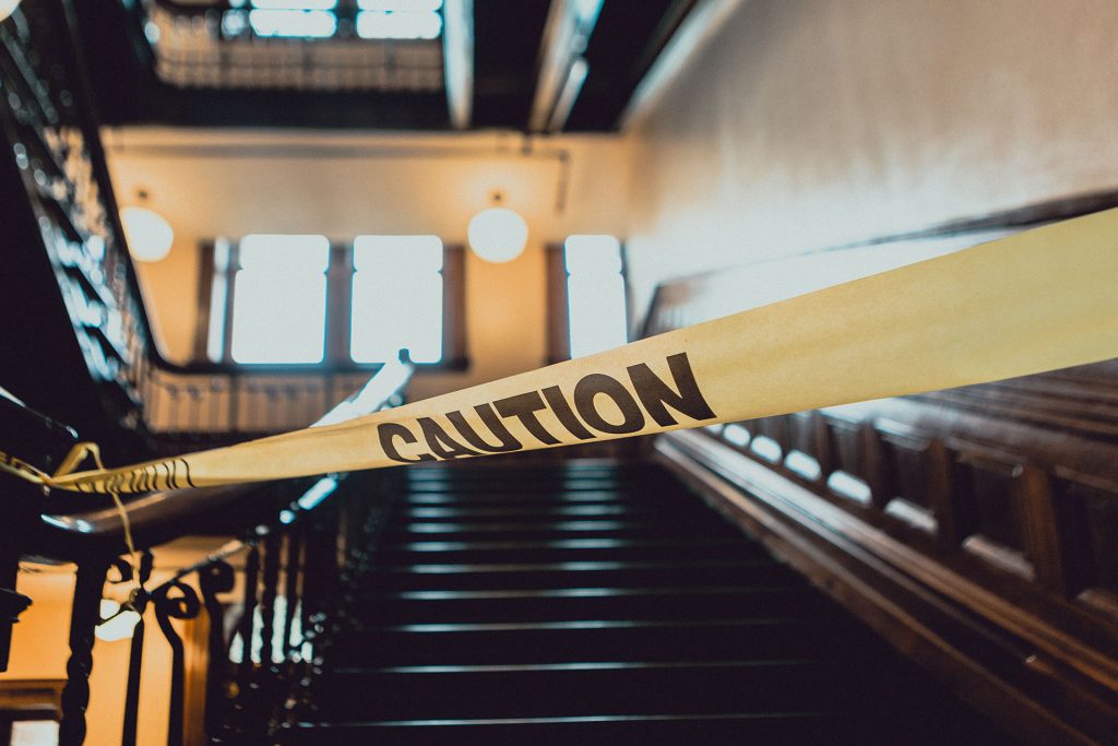 caution tape across a flight of stairs inside a building