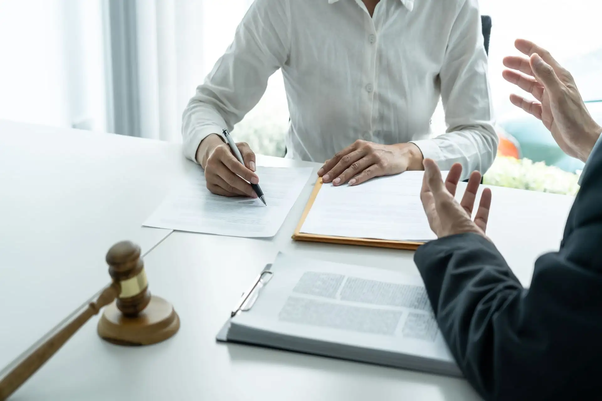 Lawyer and client reviewing legal documents with gavel on desk