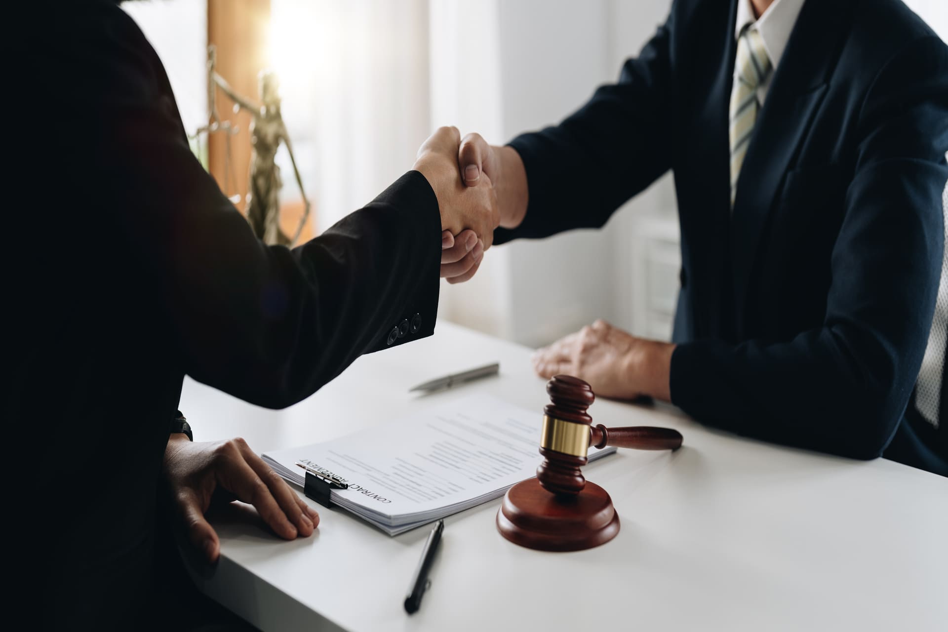 Lawyer and client shaking hands after successful legal agreement
