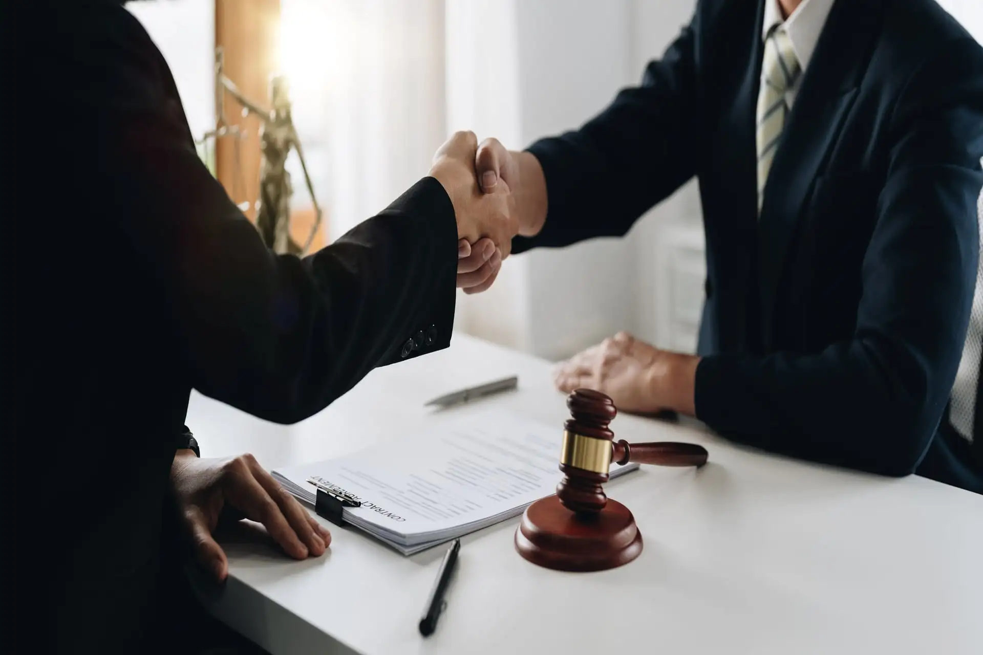 Lawyer and client shaking hands after successful legal agreement