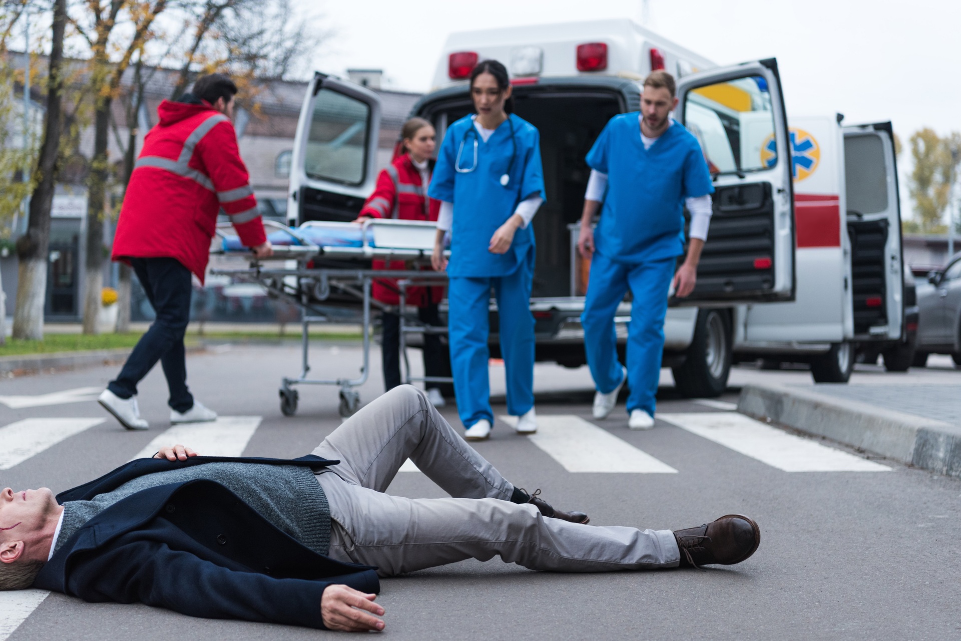 Emergency responders assisting an unconscious female accident victim on the road