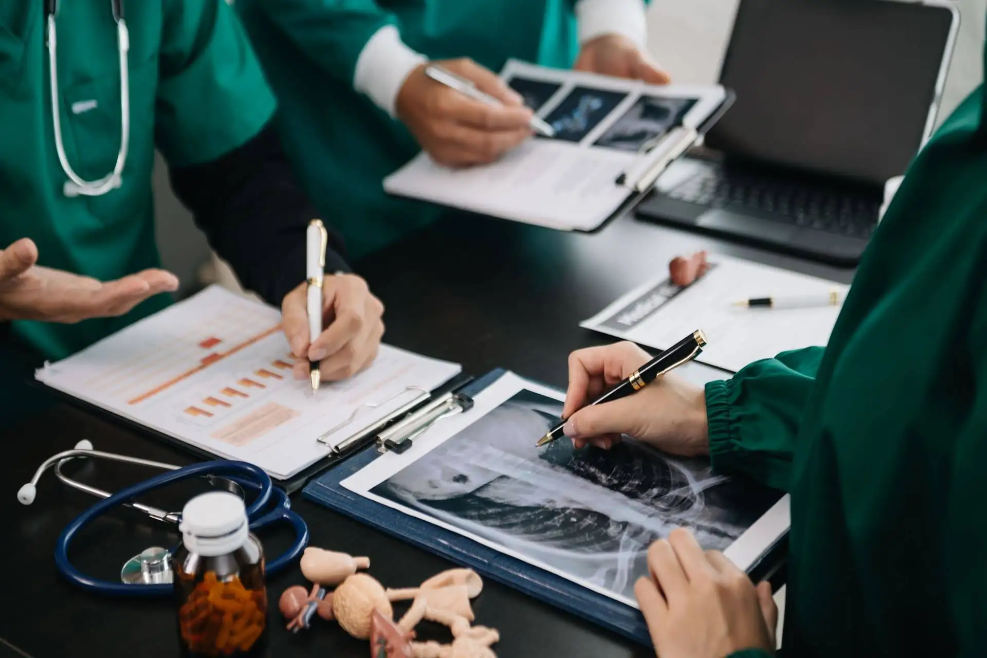 Medical team reviewing X-rays and reports during a meeting