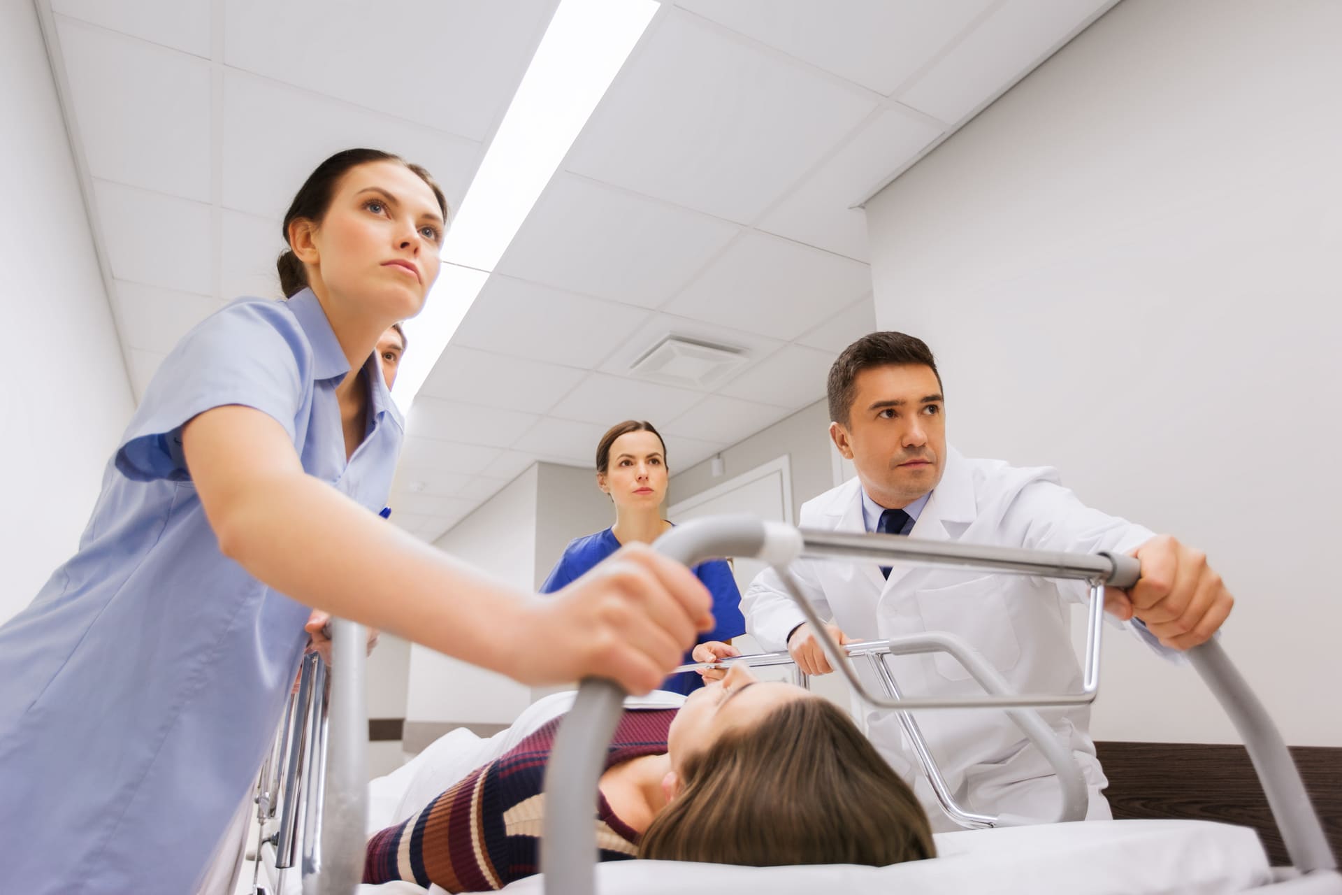 Medical team rushing patient on stretcher through hospital corridor