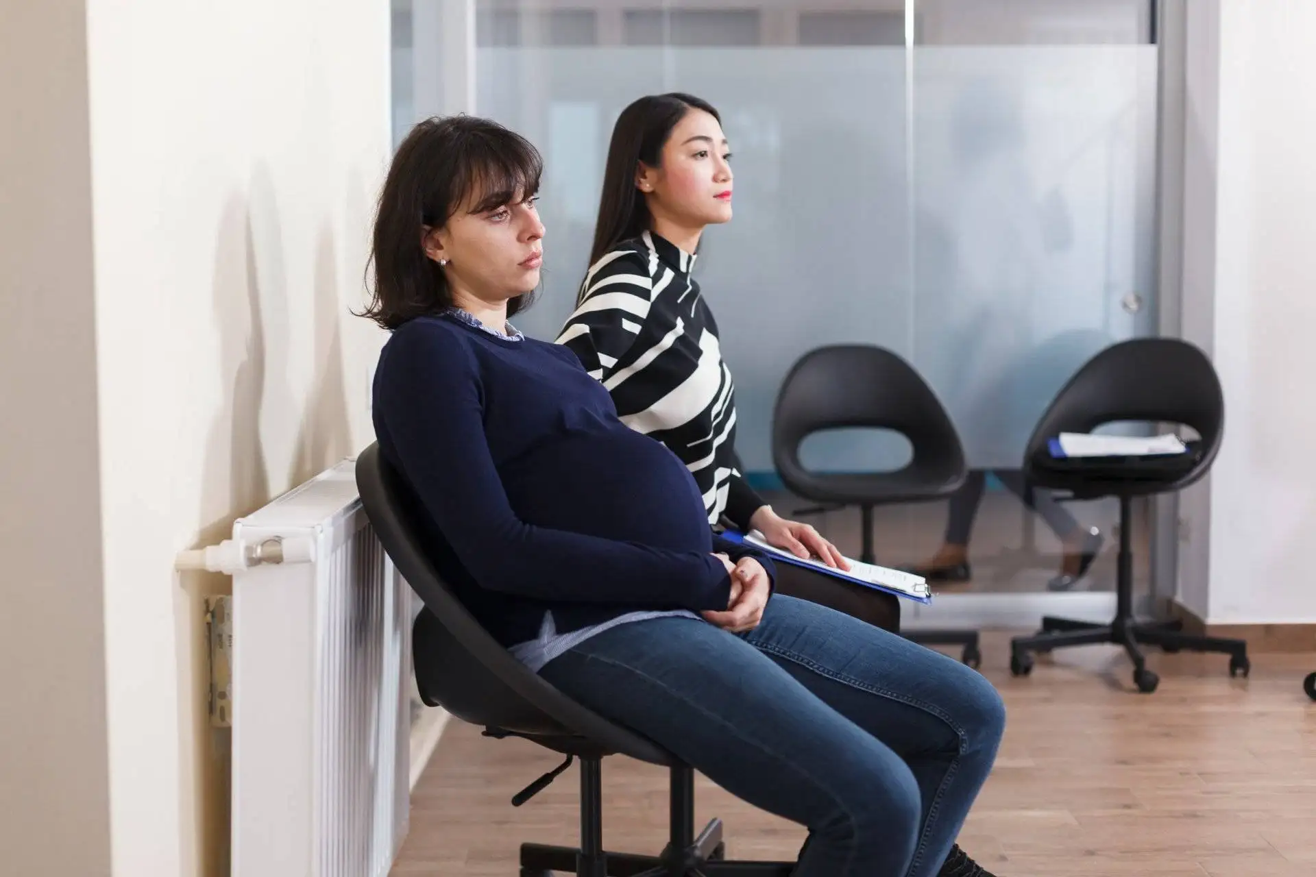 Pregnant woman and another candidate sitting in a waiting room