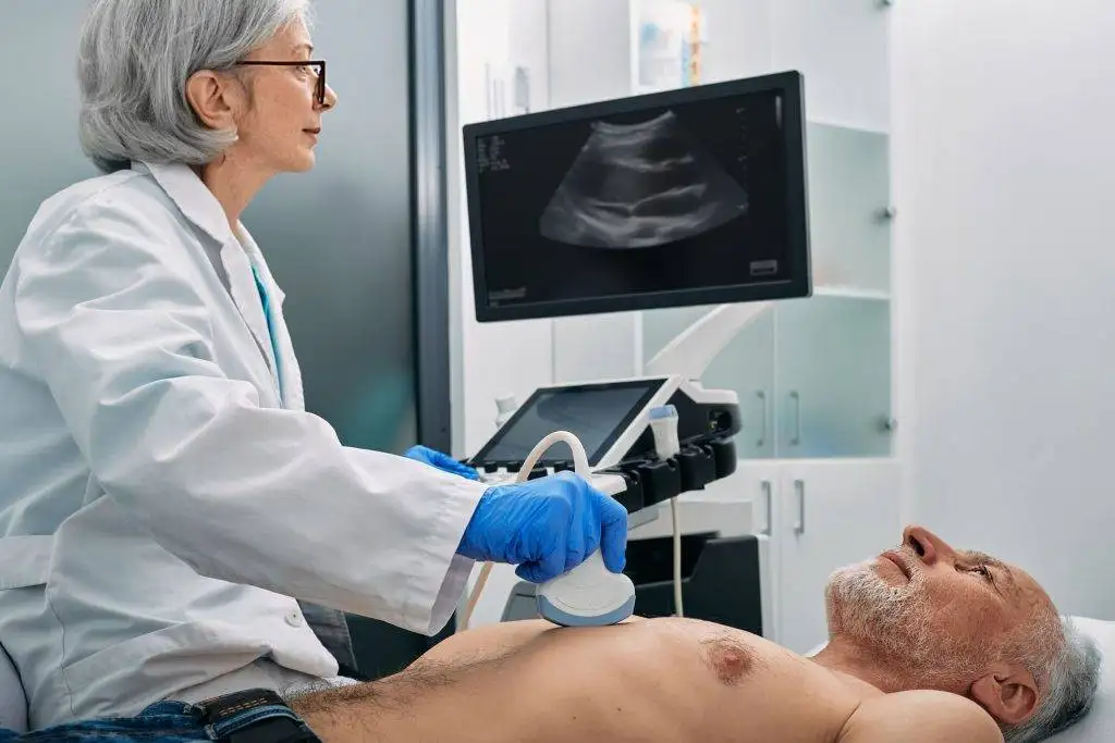 Senior man undergoing an ultrasound heart exam with a doctor operating the machine