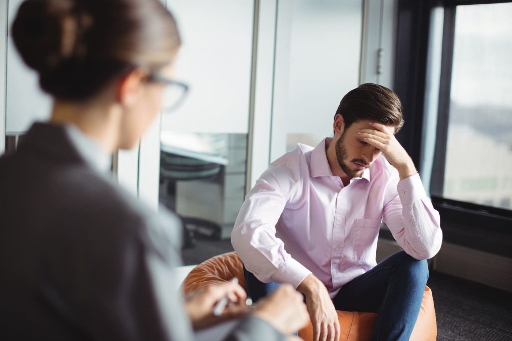 Upset man consulting a counselor during a private session