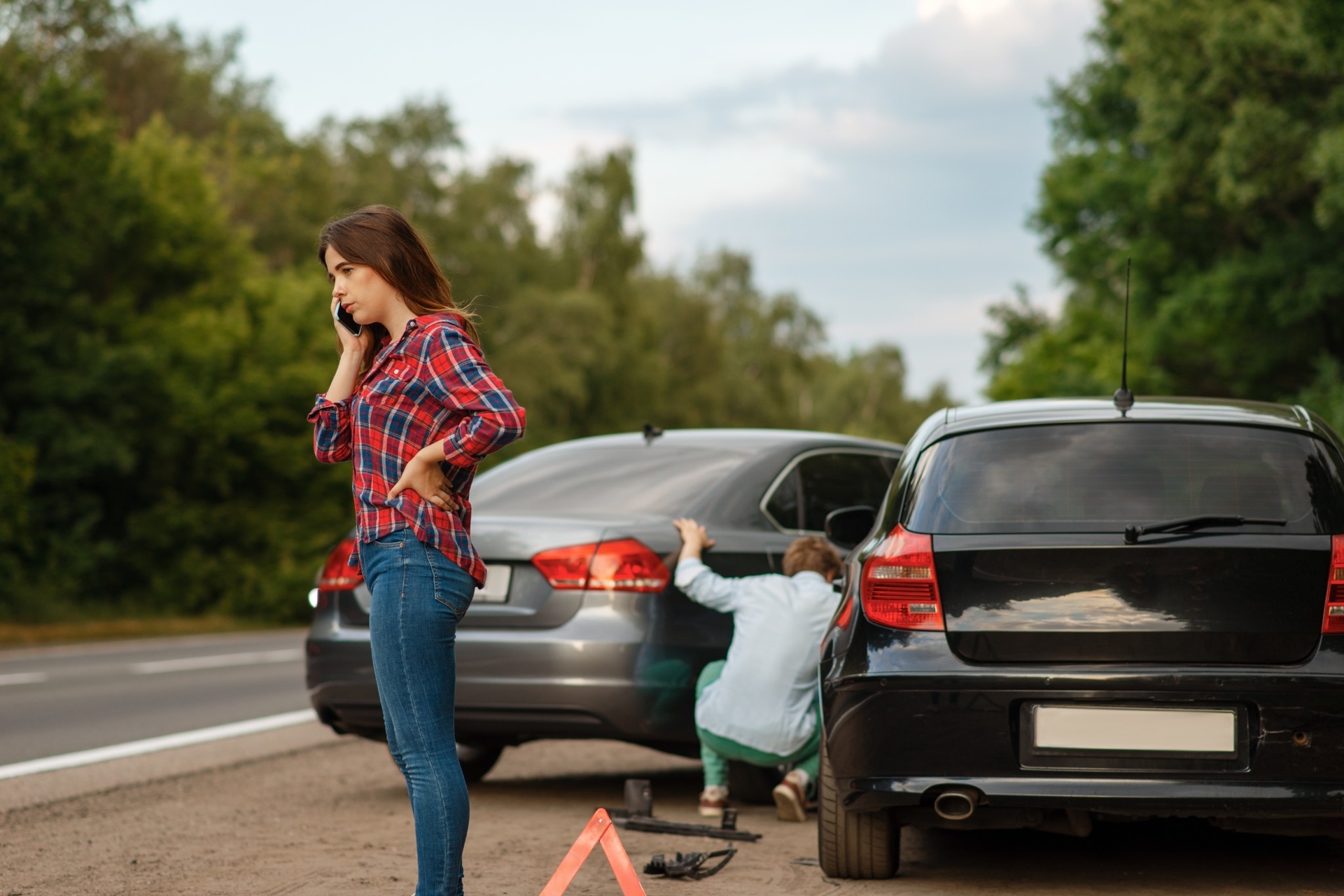 Woman calling for help after roadside car accident with another driver