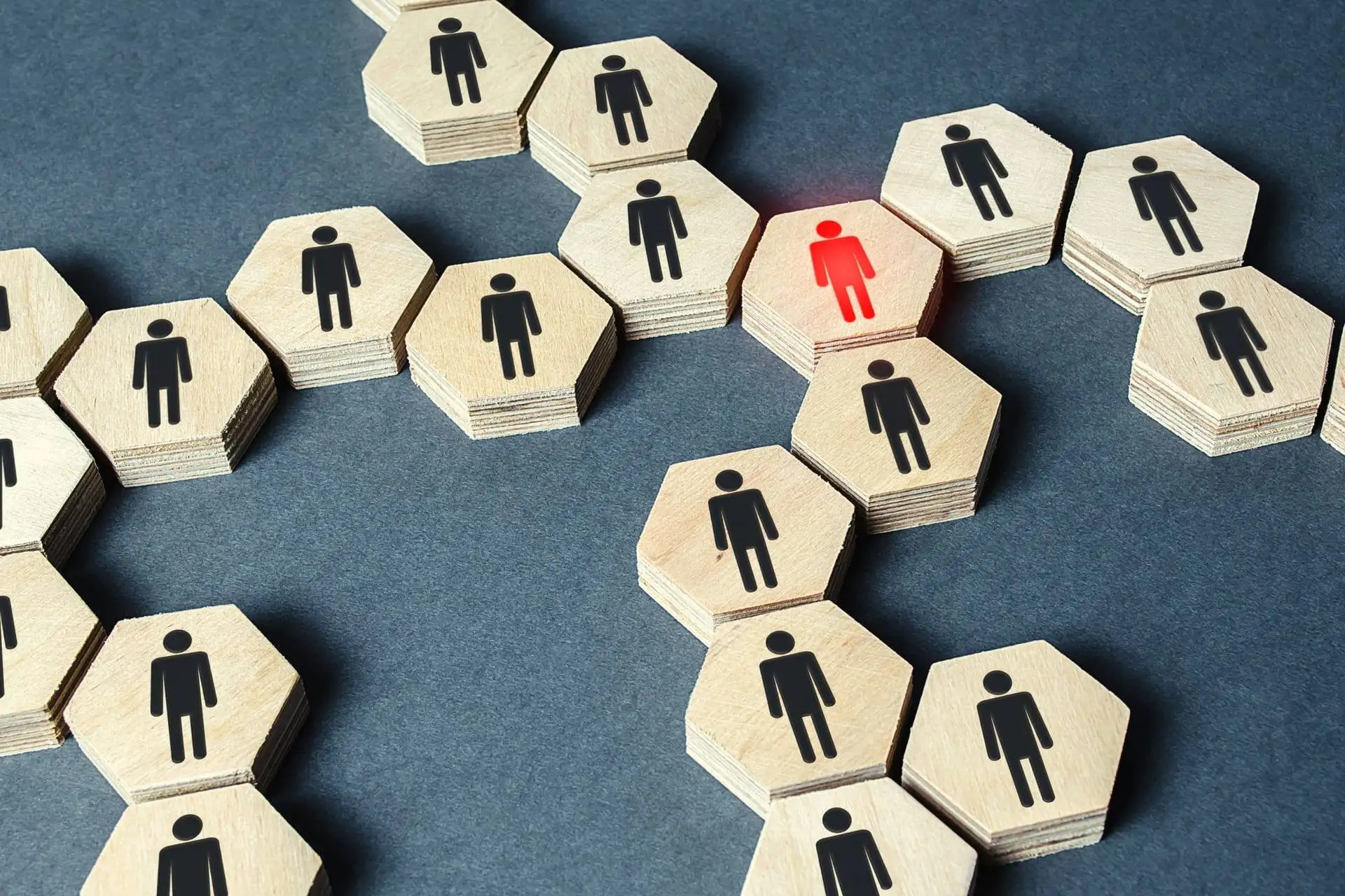 Wooden blocks with human icons highlighting one person in red