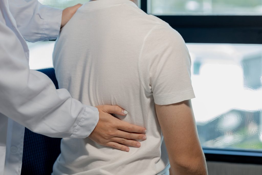 a physical therapist helping a patient with back massage