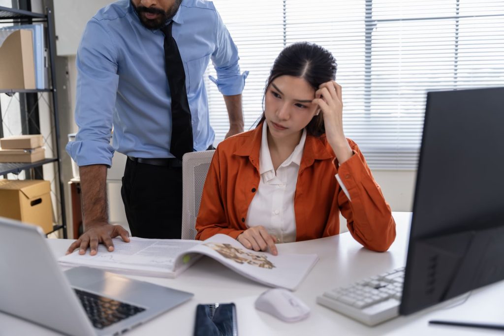 Employer scolding employee over desk