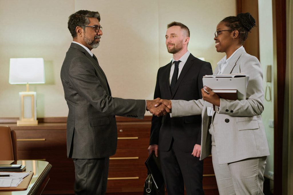 Lawyers of different races shaking band