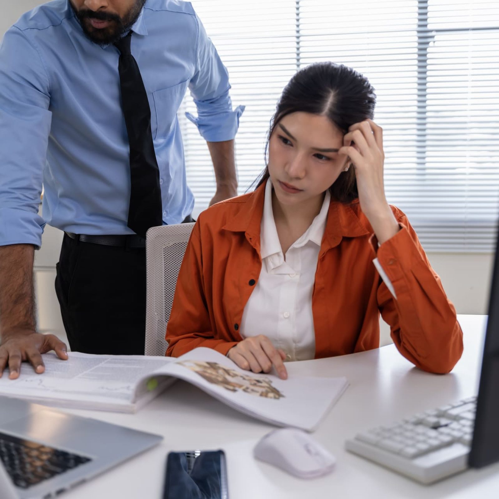 Employer scolding employee over desk