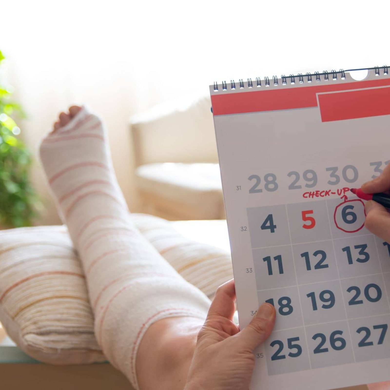 person with broken leg holding calendar