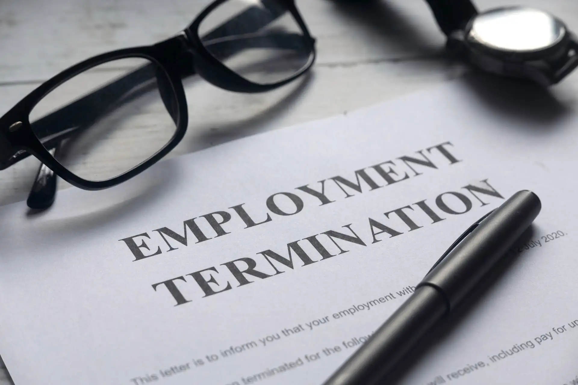 employment termination document with pen and eyeglasses