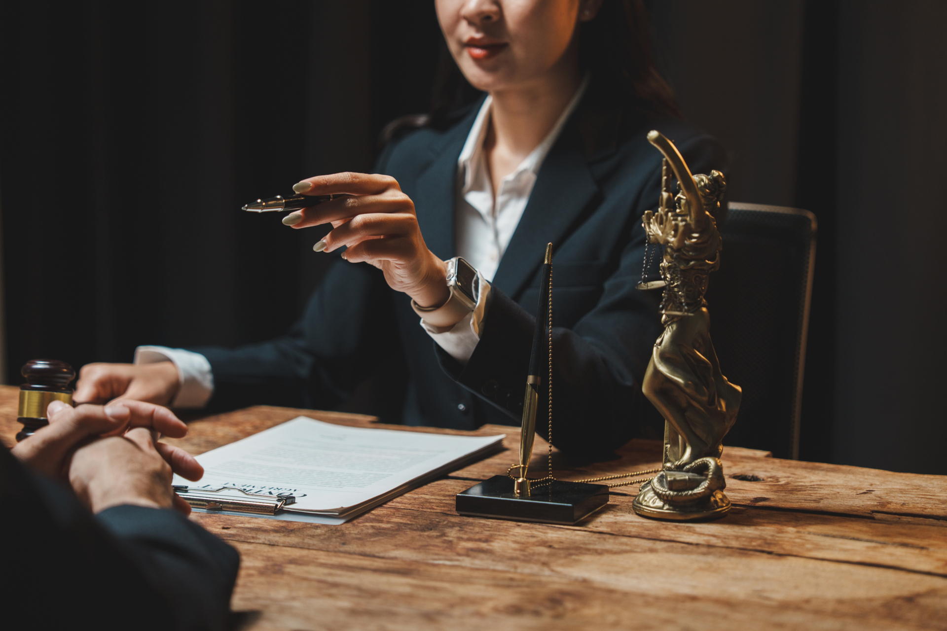 Lawyer discussing legal contract with client, signing document