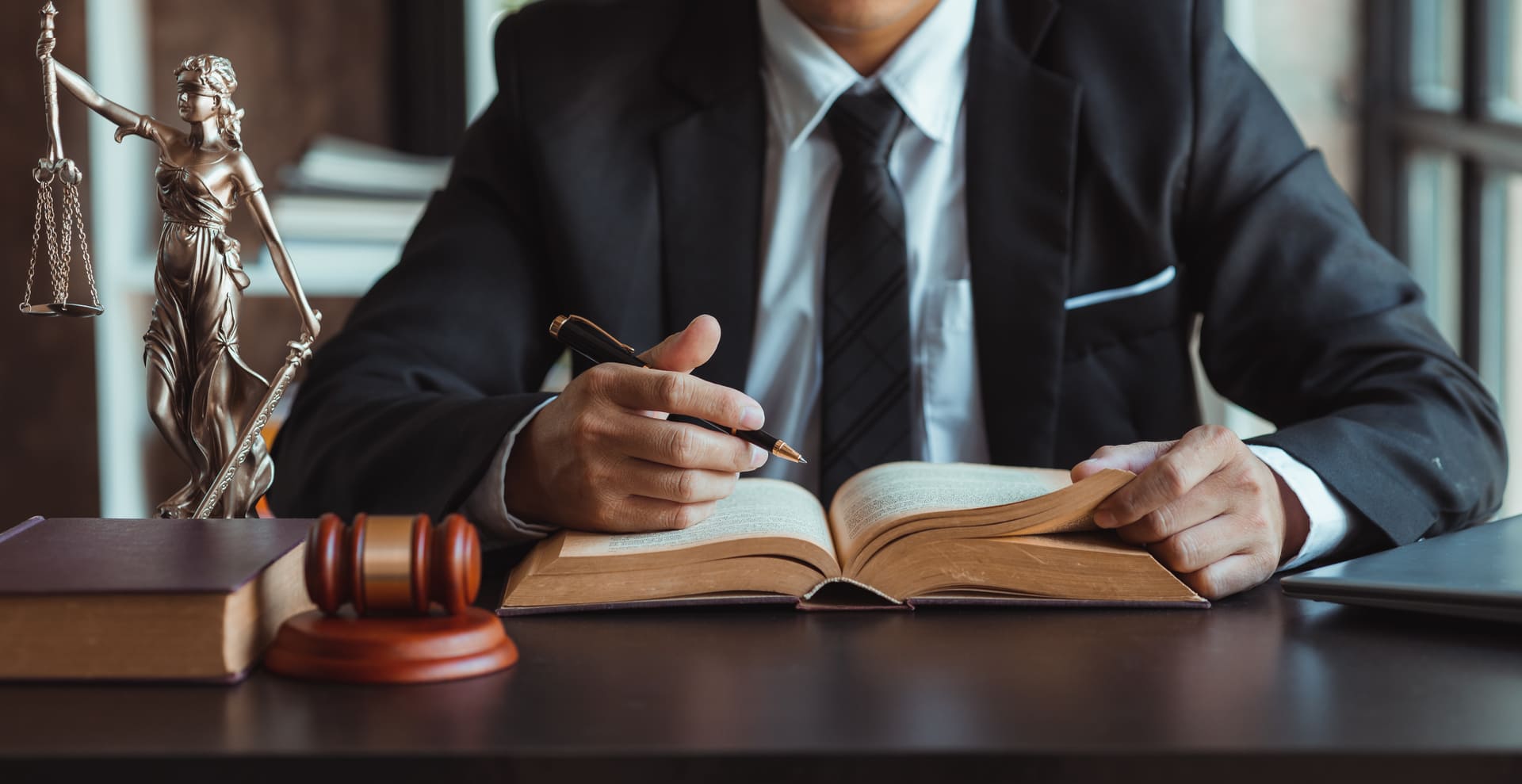 Lawyer sitting above book in office
