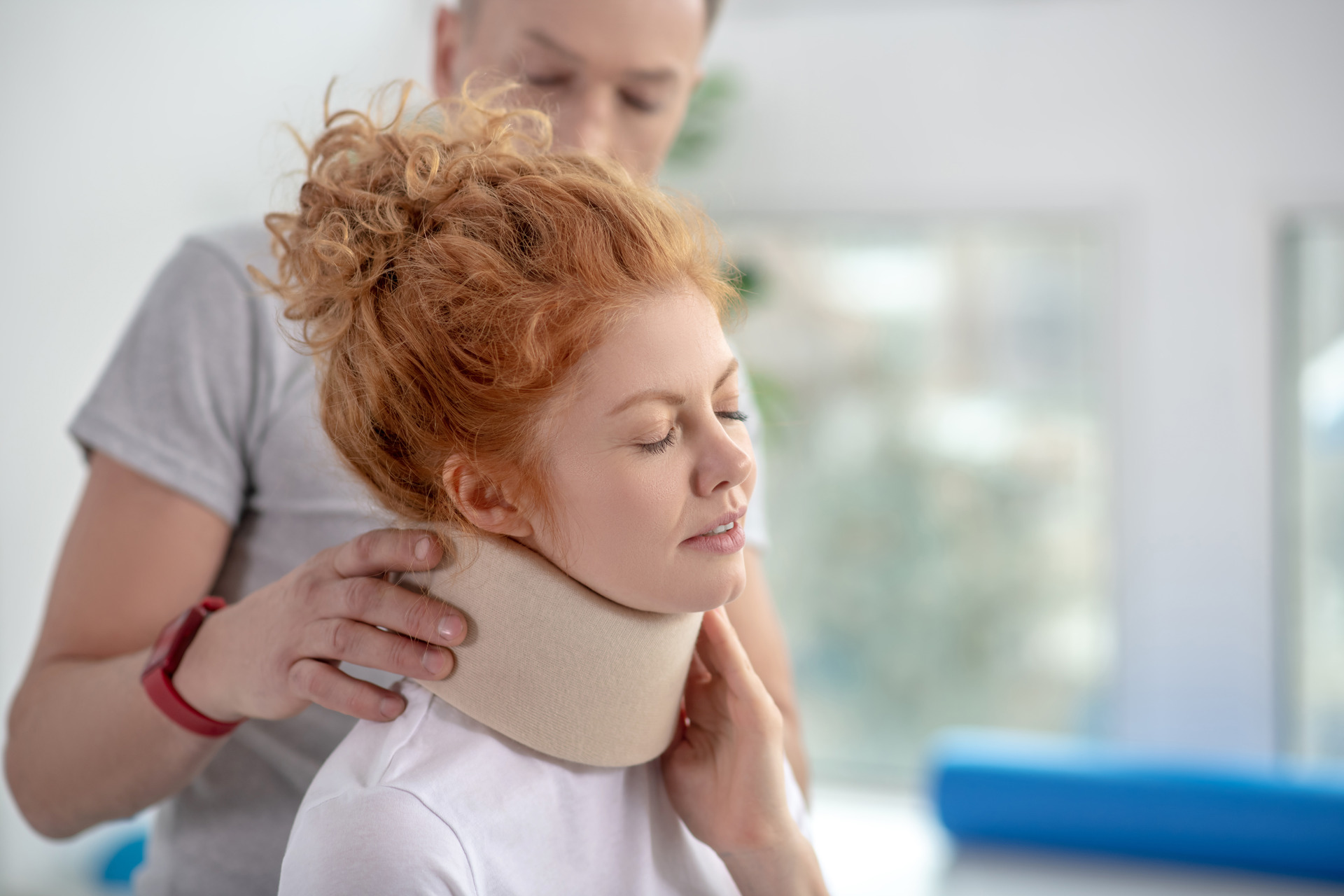 male physiotherapist examining neck fixator