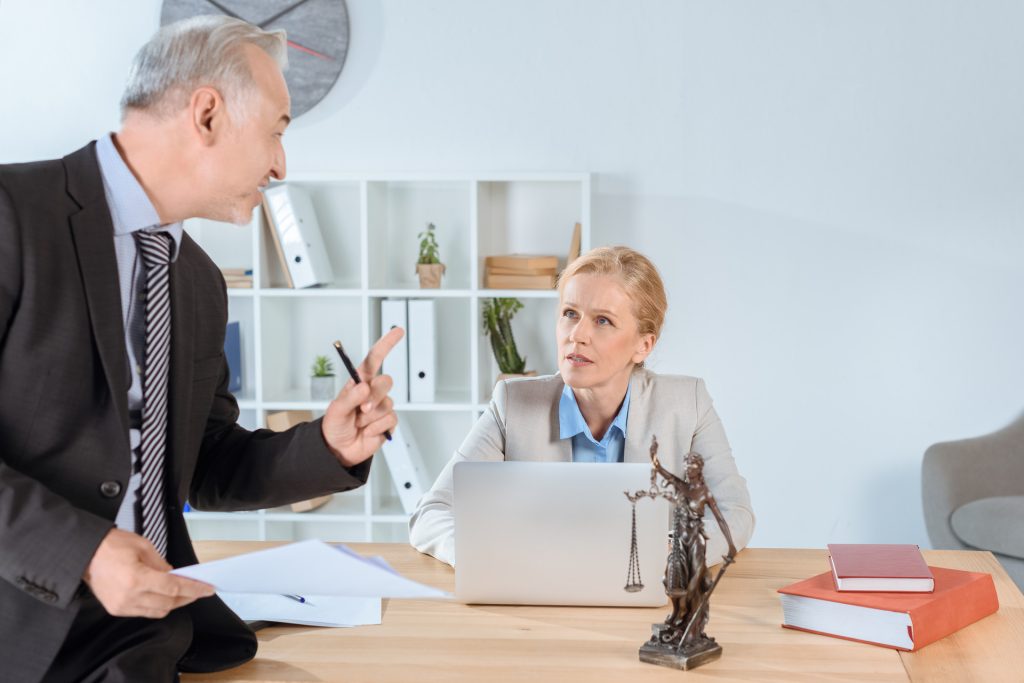 mature lawyers discussing plans at workplace