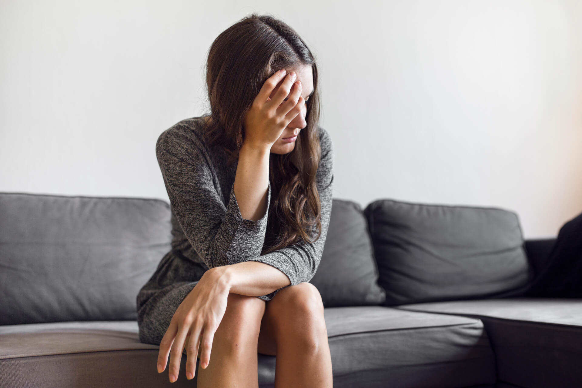 pensive sexual abuse female victim sitting on sofa