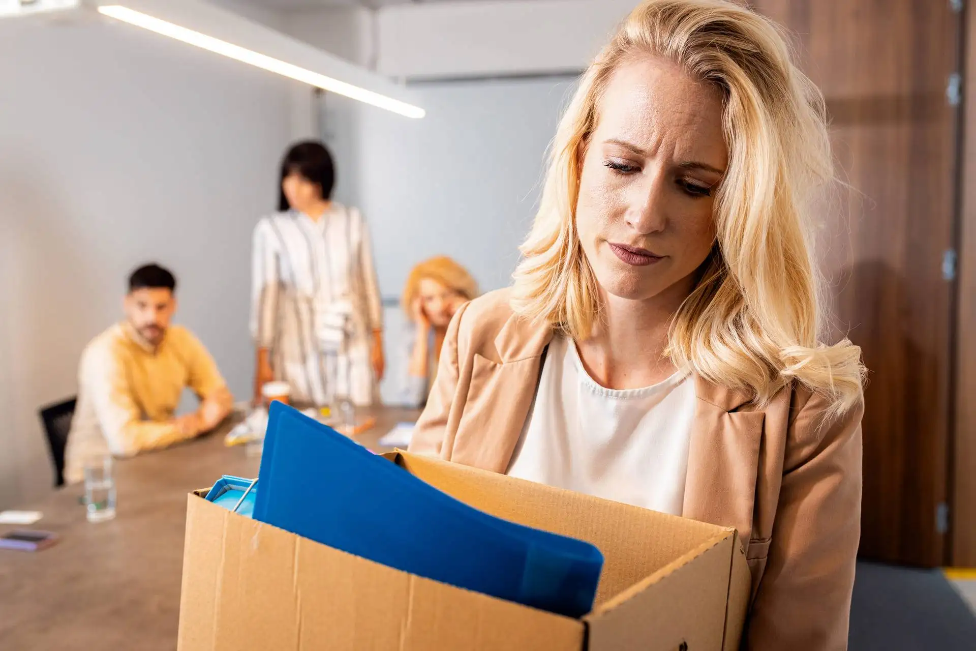portrait of woman holding box of personal belongin