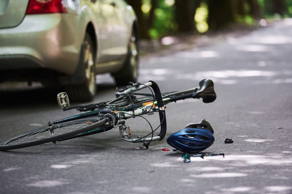 Crashed bicycle with car in background