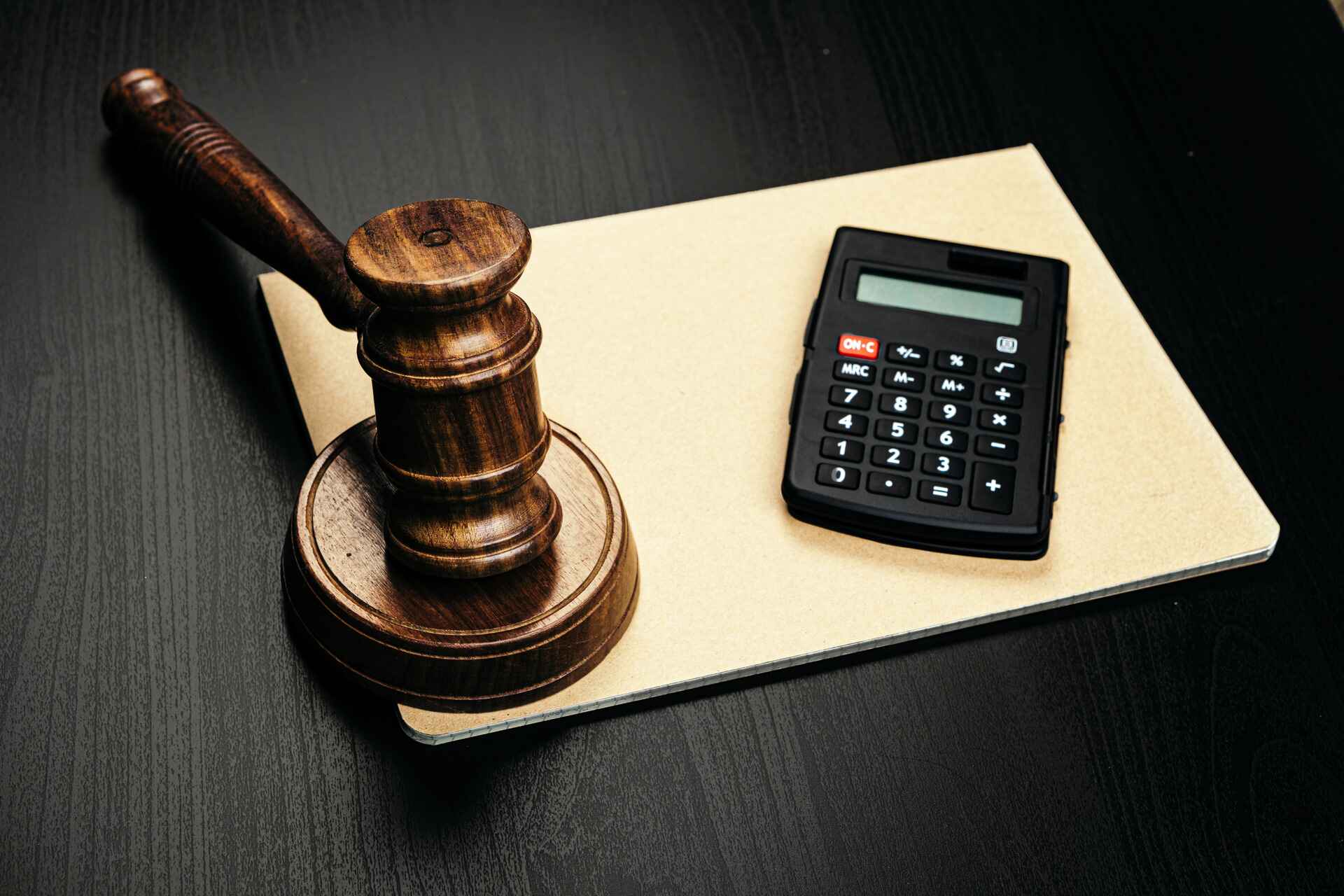 wooden judge gavel and calculator on table